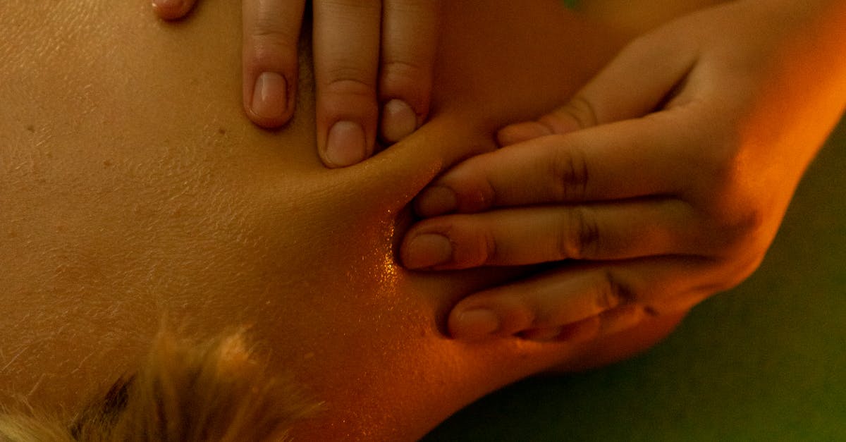 From above of anonymous slim female with short hair lying on stomach and resting during massage session